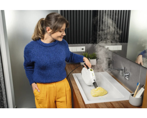 Kvinna rengör handfat med Kärcher ångrengörare i badrummet