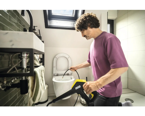 Man rengör toalett med en Kärcher högtryckstvätt i badrummet.