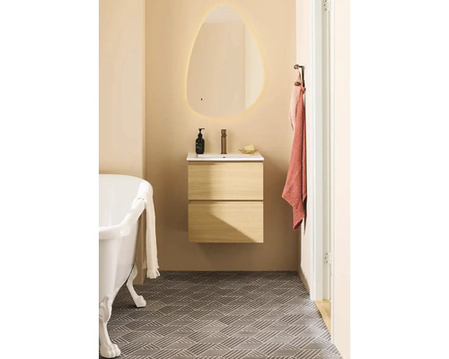 Badrum med badkar, tvättställ med underskåp och belyst spegel