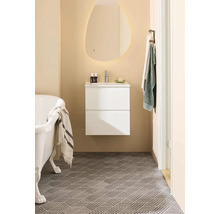 Badrum med badkar, tvättställ, spegel med belysning och handdukshängare