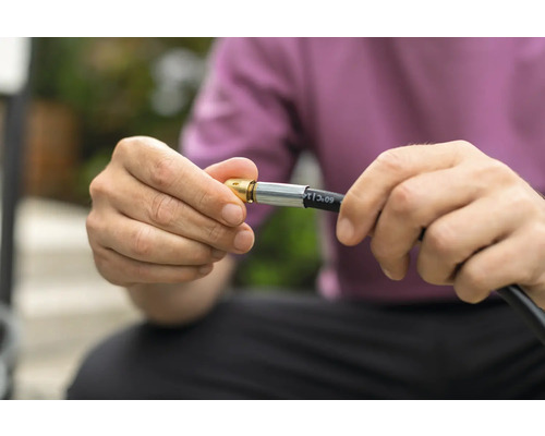 En person ansluter en gasslang till en anslutning.