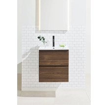 Tvättställ med underskåp och spegel i ett ljust badrum