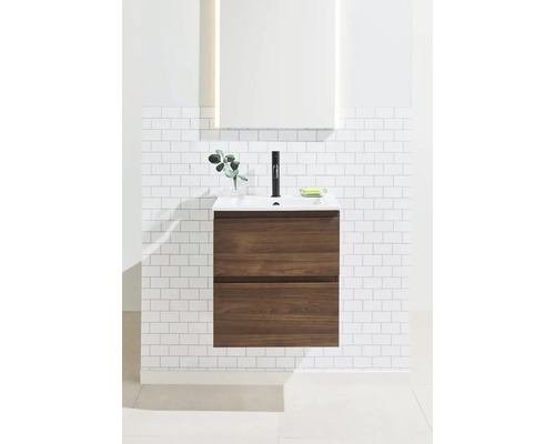 Tvättställ med underskåp och spegel i ett ljust badrum