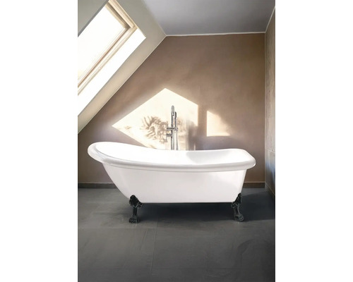 Fristående badkar med armaturer i ett badrum med takfönster