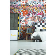 Ett sovrum med graffititapet, säng, stol och dekorationer.