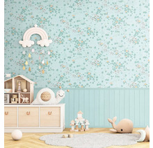 Ljust barnrum med blommig tapet, träbyrå och leksaker