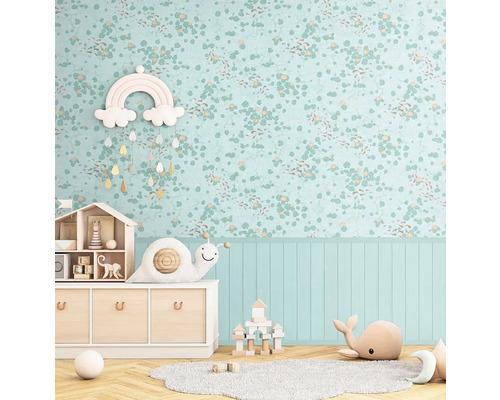 Ljust barnrum med blommig tapet, träbyrå och leksaker