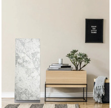 Interiör med marmorelement, träbord med växt och dekoration samt en inramad inskription