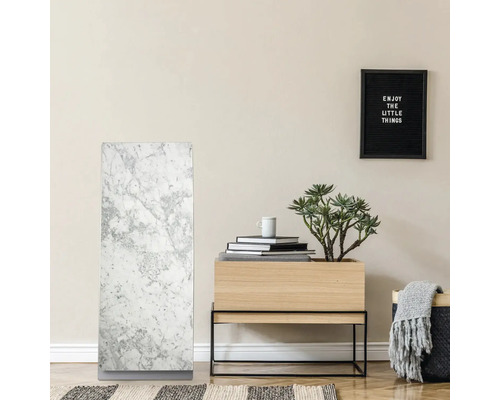 Interiör med marmorelement, träbord med växt och dekoration samt en inramad inskription