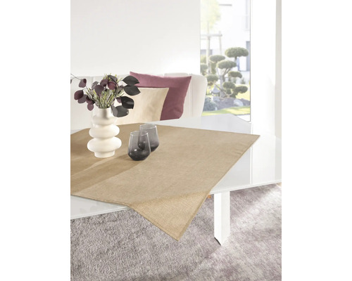 Dekorativt arrangemang med bordslöpare, blomvas och glas på ett matbord