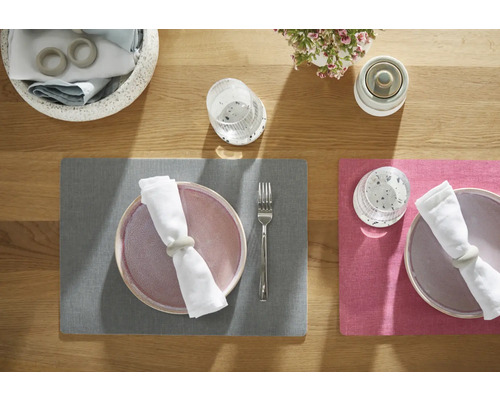 Bordsdekoration med bordstabletter, tallrikar, servetter, servettringar, glas, bestick och blomsterdekorationer på ett träbord