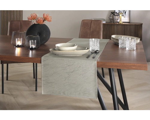 Dekorativt matbord med bordslöpare, porslin, glas, ljusstakar och blomvas