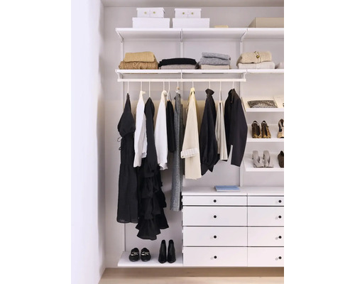 Garderob med kläder, skor och förvaringsboxar i ett ljust rum.