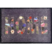Dörrmatta med blommönster och ordet HOME