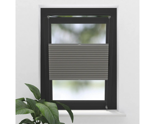 Grå plisségardiner på fönstret för ljusreglering