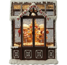 Dekorativt pepparkakshus med pepparkaksgubbar och snö som juldekoration