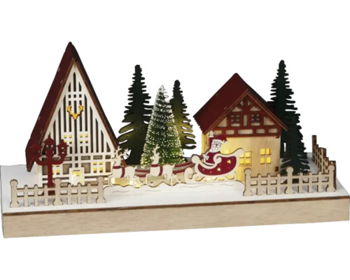 Dekorativt jullandskap med hus, julgranar, renar och jultomten i en släde