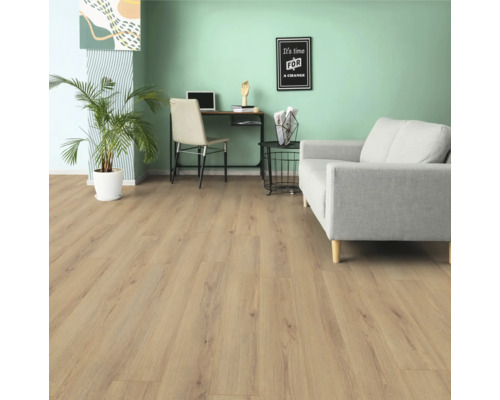 Vardagsrum med ljust trägolv, soffa, skrivbord och krukväxt