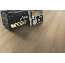 Ljust laminatgolv i vardagsrum med förstärkare och tidning