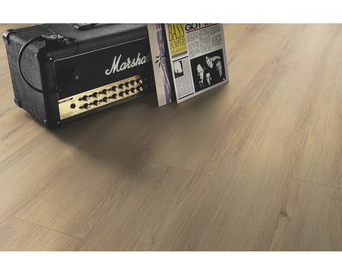 Ljust laminatgolv i vardagsrum med förstärkare och tidning