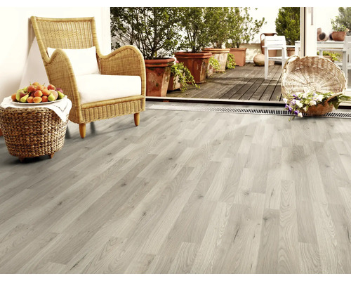 Ljust trägolv i ett vardagsrum med rottingfåtölj och dekoration