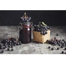 Aronia i en glasburk och korg på ett bord