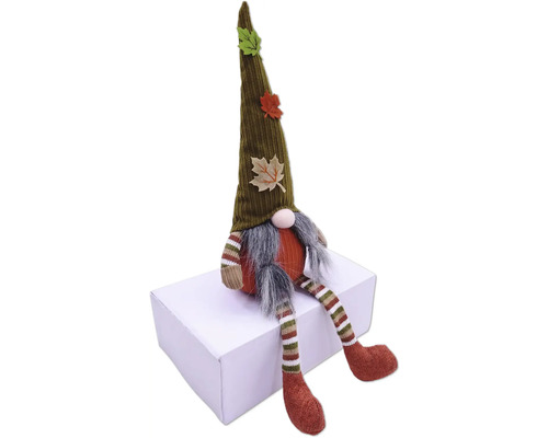 Dekorativ tomte med mössa och höstlöv sitter på en låda