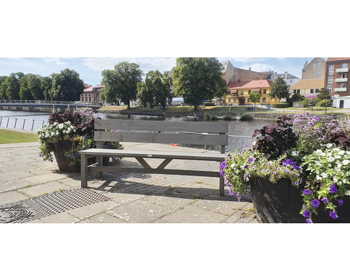 Grå träbänk utomhus nära blomlådor