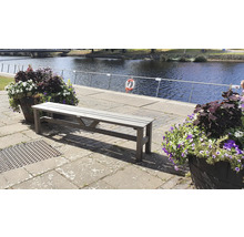 Träbänk vid stranden med blomlådor