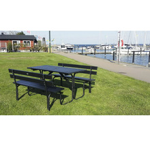 Bord med bänkar utomhus på gräsmatta med utsikt över en marina