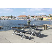 Picknickbordset med bord och två bänkar vid vattnet