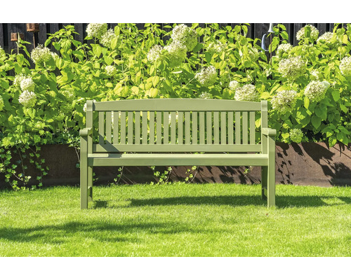 Trädgårdsbänk i trä framför växter