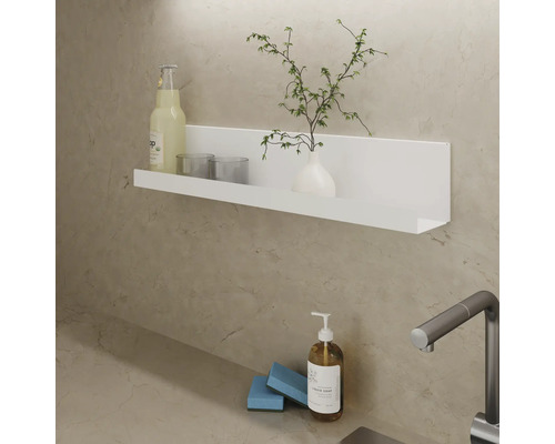 Vägghylla med dryck, glas, vas och växt ovanför diskbänk med tvålpump och svamp