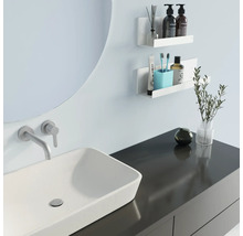 Modernt badrum med handfat, spegel och vita hyllor för förvaring av badrumsartiklar