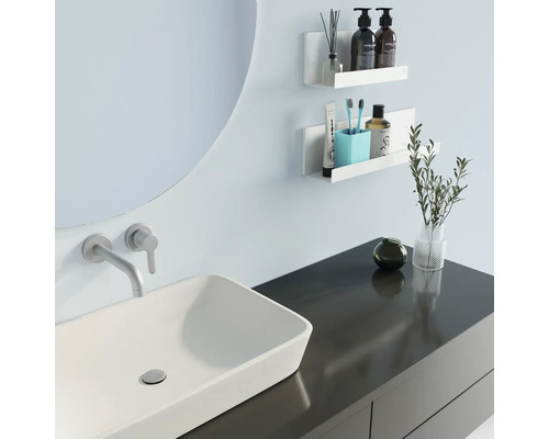 Modernt badrum med handfat, spegel och vita hyllor för förvaring av badrumsartiklar