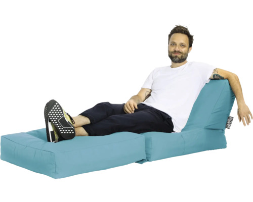 Man slappnar av på en blå saccosoffa.
