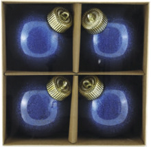 Fyra blå julgranskulor med gyllene hängare i en kartong.