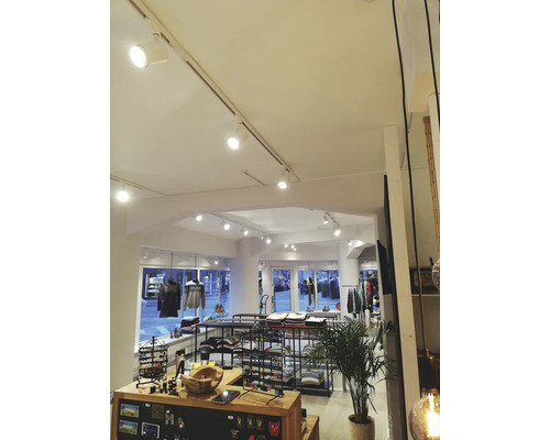 Interiör av en klädaffär med produktvisning och belysningssystem