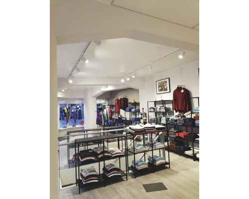 Interiör av en klädaffär med hyllor fulla av kläder.