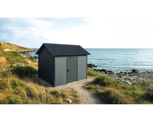 Trädgårdsskjul i trä med ståldörr nära havet