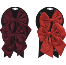 Två dekorativa sammetsrosetter på en detaljhandelsförpackning