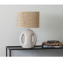 Bordslampa med lampskärm av bast på ett svart bord