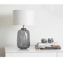 Dekorativ bordslampa i glas med lampskärm på ett bord