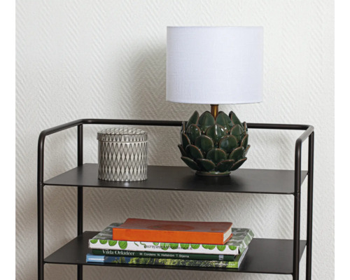 Dekorativ hylla med lampa, burk och böcker