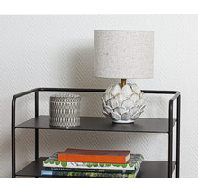 Dekorativ hylla med lampa, burk och böcker
