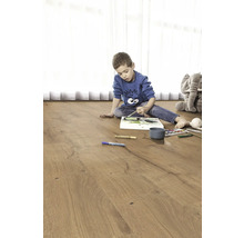 Barn målar på ett trägolv. I bakgrunden finns en gosedjurs elefant.