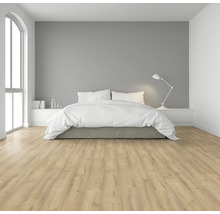 Ljust sovrum med dubbelsäng, sänglampa och laminatgolv