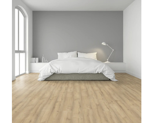 Ljust sovrum med dubbelsäng, sänglampa och laminatgolv