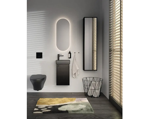 Badrum med handfat, spegel, toalett och tvättkorg