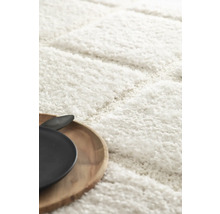 Detaljvy av en vit ryamatta med träbricka och porslin